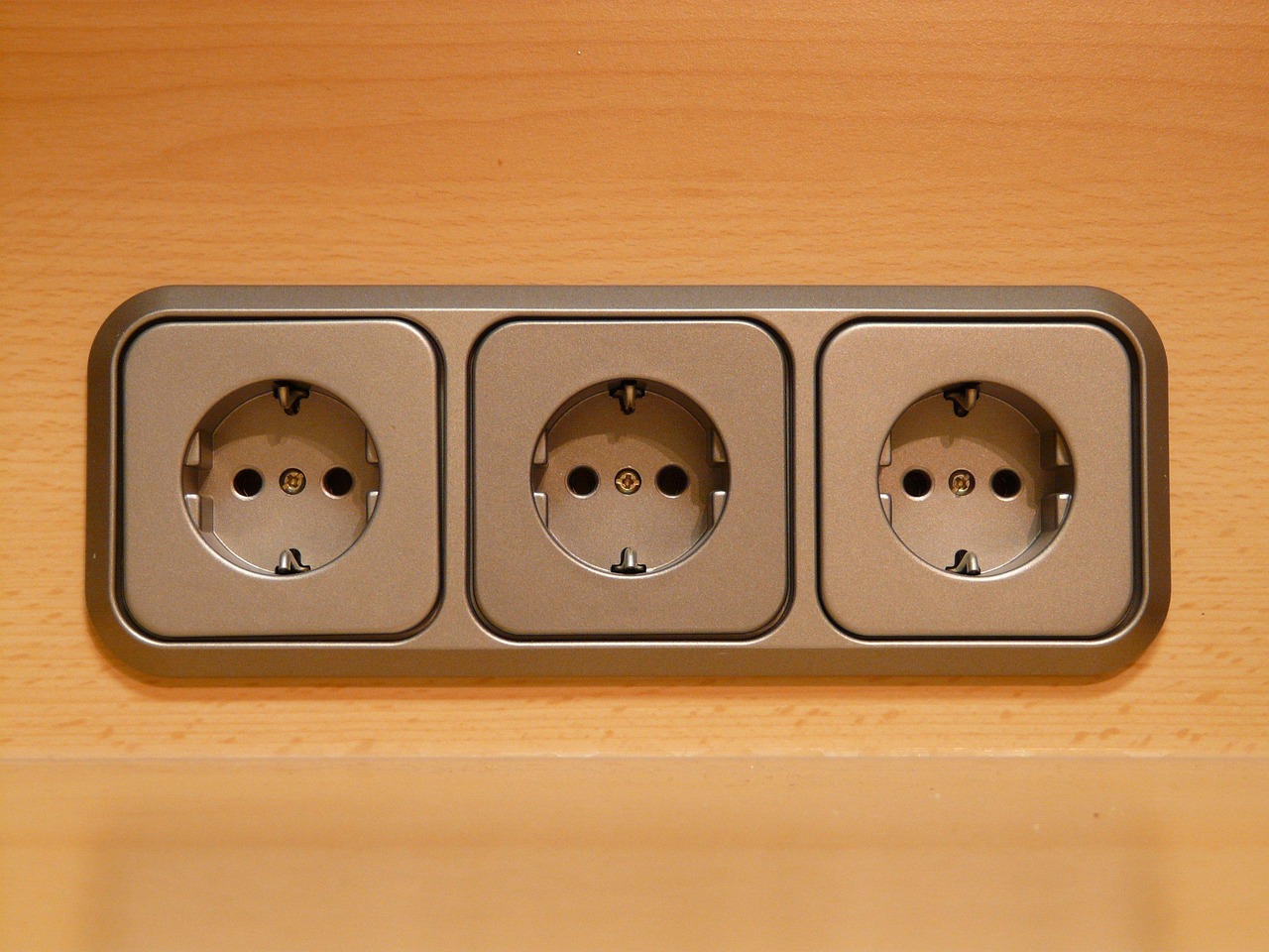 Three sockets on wooden surface Three sockets on wooden surface